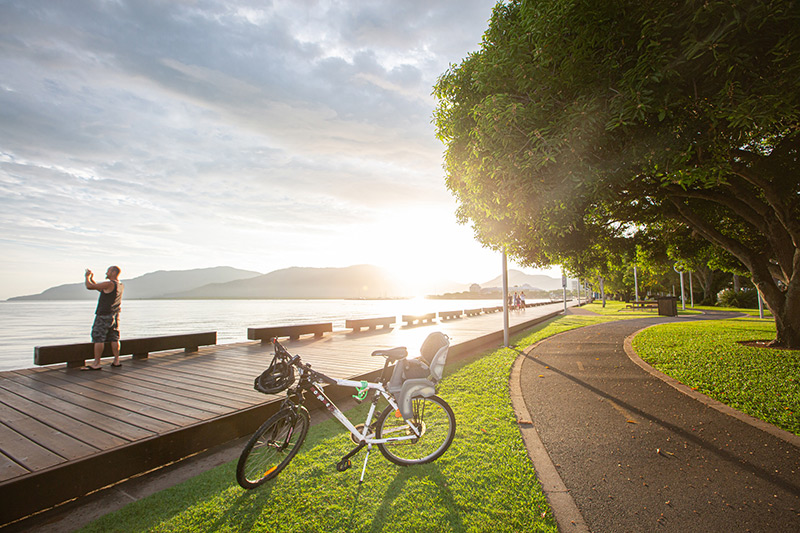 Cyclist taking a photo at sunrise on the Esplanade